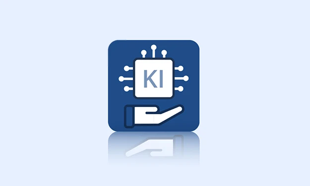 **Prägnante barrierefreie Bildbeschreibung:**

Ein blauer Icon zeigt einen Mikrochip mit der Aufschrift „KI“, umgeben von Verbindungslinien. Darunter hält eine stilisierte Hand den Chip – Symbol für unterstützende Künstliche Intelligenz.