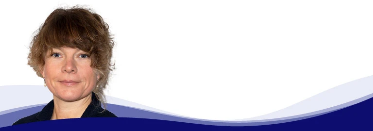 Sabrina Haas, zuständig für Marketing Services bei CREATON, schaut ruhig in die Kamera und lächelt leicht. Sie hat mittellange, lockige, hellbraune Haare mit Pony. Sie trägt eine dunkle Bluse und goldene Ohrringe.