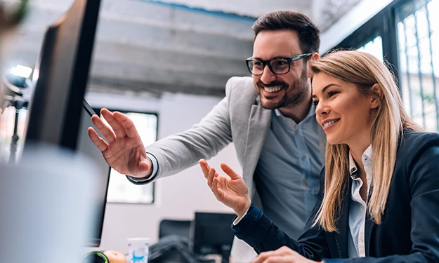 An IT employee operates a laptop in a server room