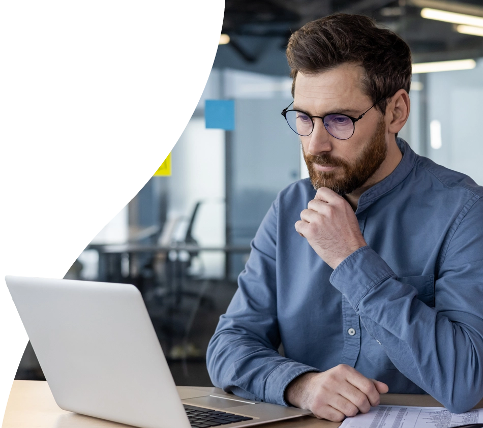 A man ponders on his laptop whether he should opt for a cloud or on-premise PIM system